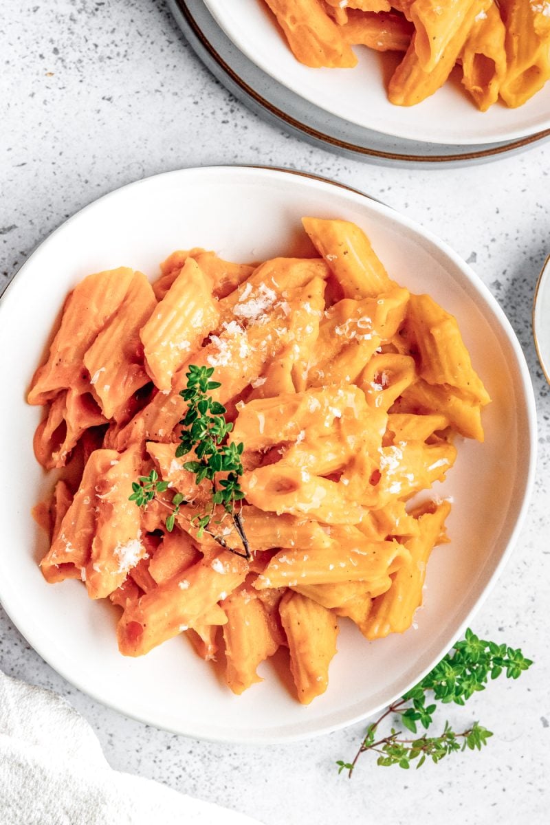 Closeup image on butternut squash pasta in a white bowl. 