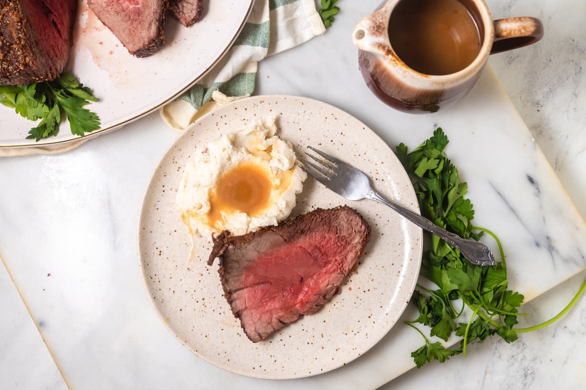 Plated roast beef dinner with mashed potatoes and gravy. 