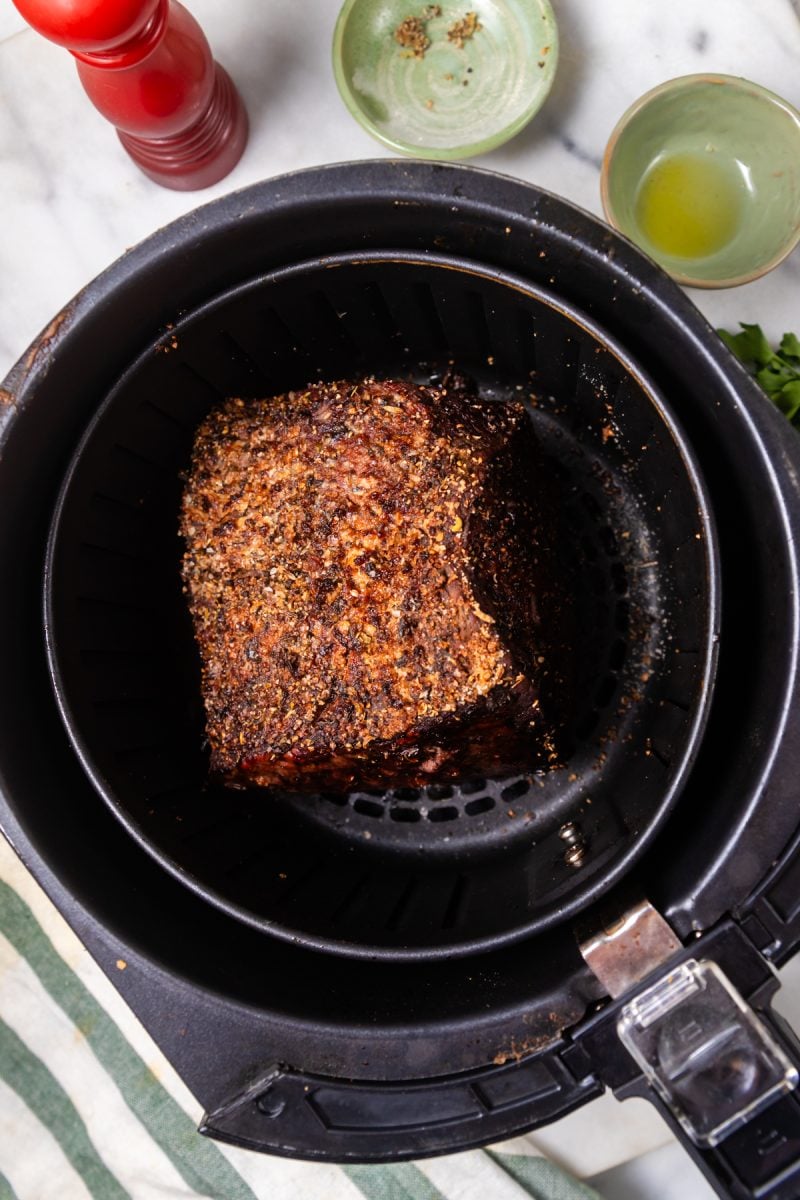 Air fried roast beef in an air fryer basket. 